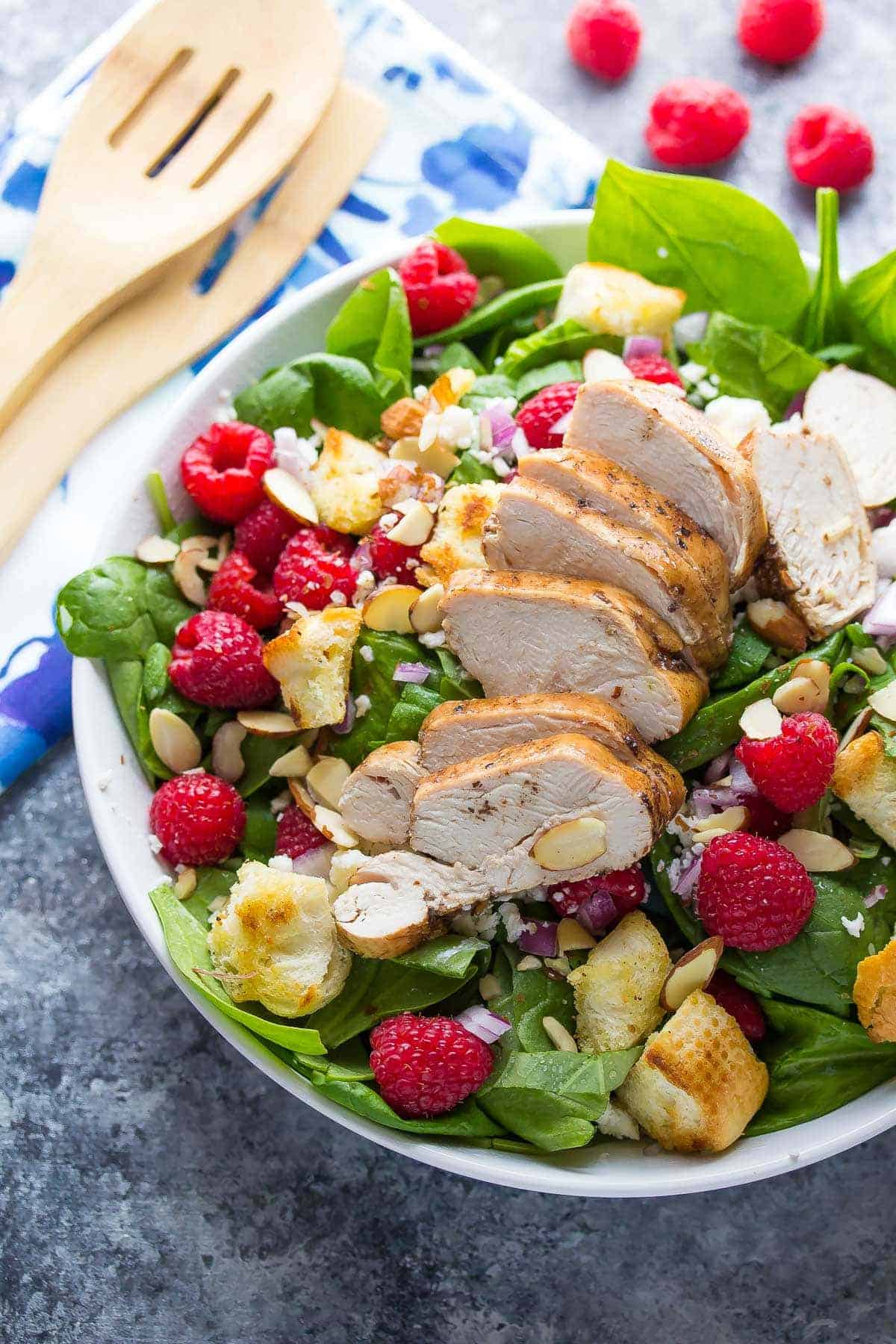 Full bowl of Raspberry Spinach Panzanella Salad with Chicken on top