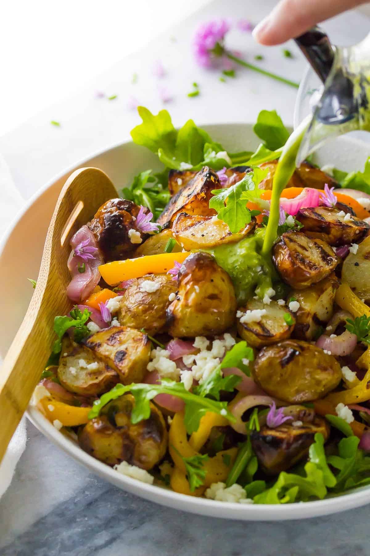  pouring vinaigrette over grilled potato salad