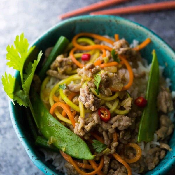 blue bowl with thai ground pork stir fry in blue bowl with chopsticks