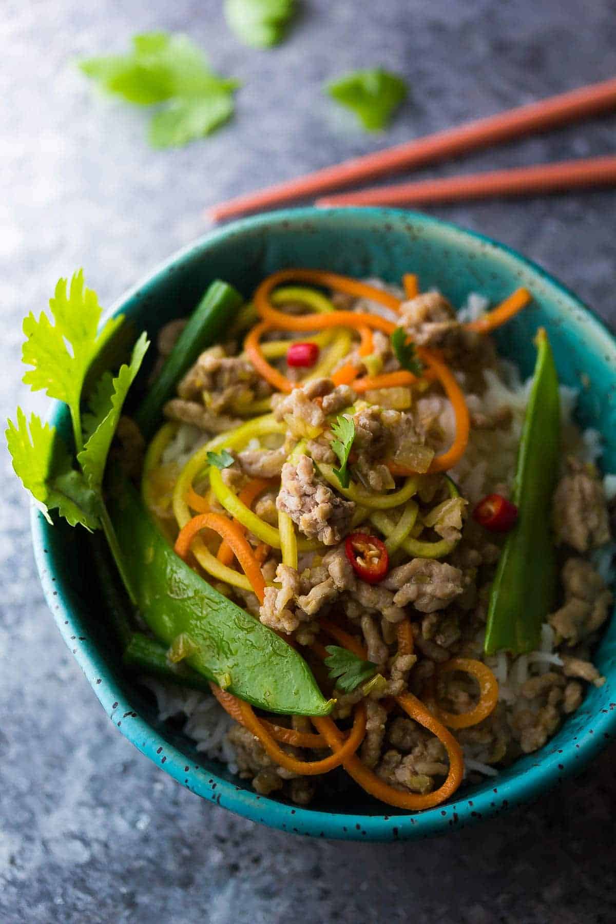 Lemongrass Thai Ground Pork Stir Fry in a blue bowl with red chopsticks