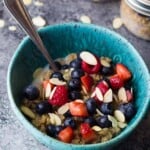 blue bowl with berry almond breakfast quinoa and spoon