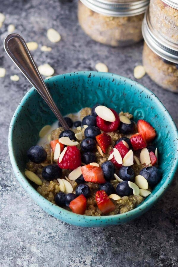 blue bowl with berry almond breakfast quinoa and spoon