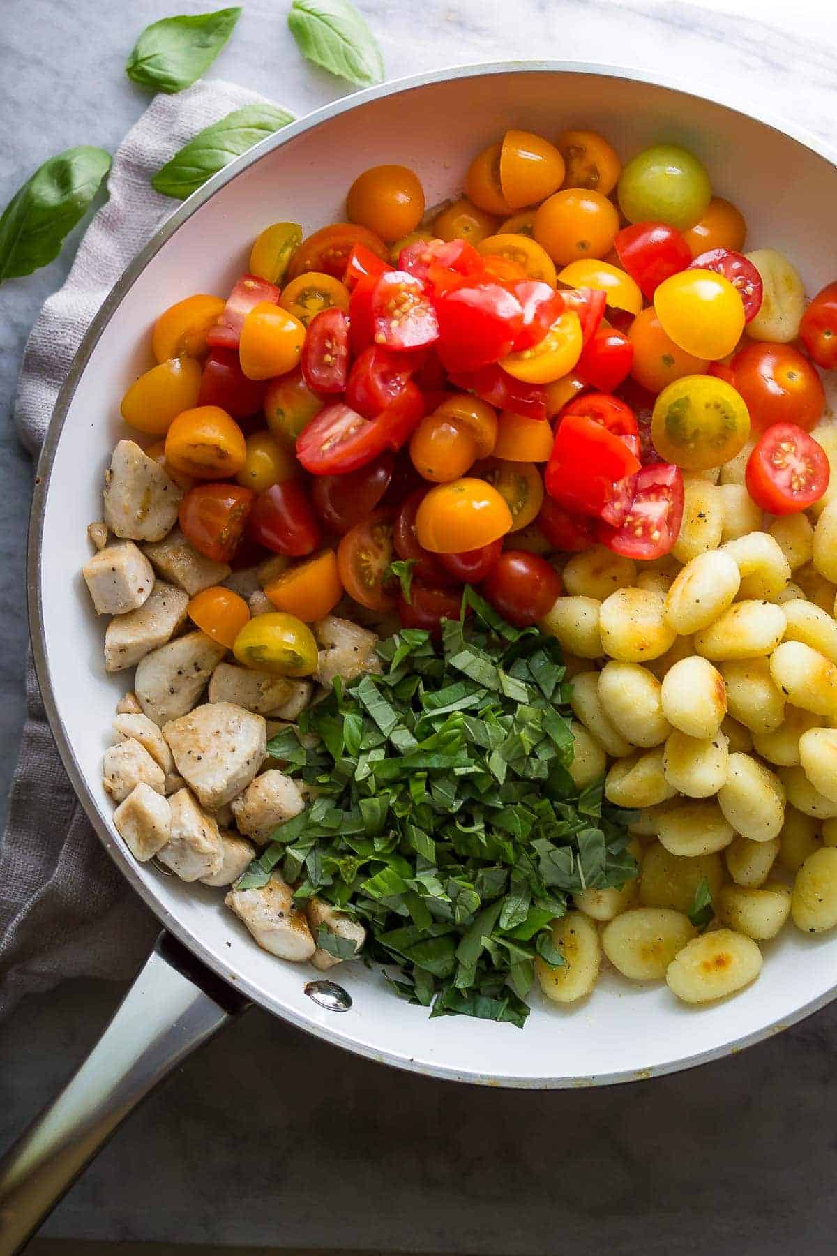 Caprese Chicken Gnocchi ingredients in a skillet