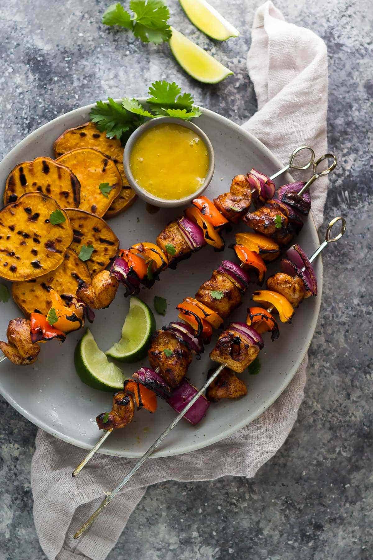 Plated Chili Lime Chicken Skewers with Mango Sauce and grilled sweet potato slices
