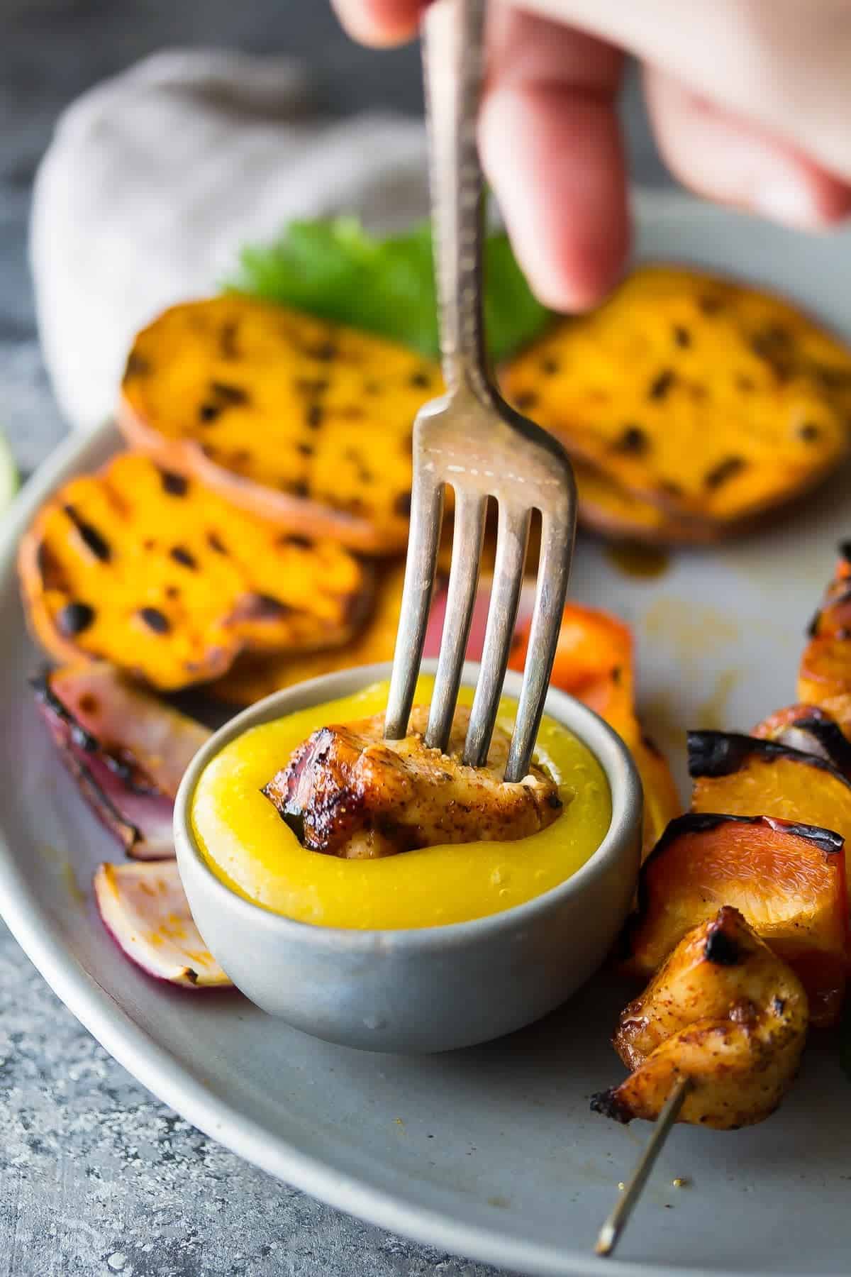 Chili Lime Chicken being dunked in Mango Sauce