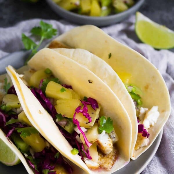 three grilled fish tacos with jalapeno kiwi salsa and cilantro and lime