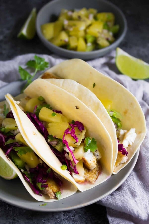 three grilled fish tacos with jalapeno kiwi salsa and cilantro and lime