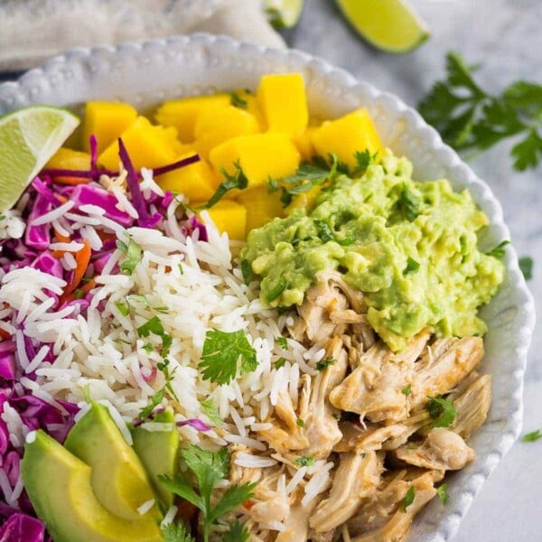 sweet chili chicken bowls with mango and cashews in large white bowl