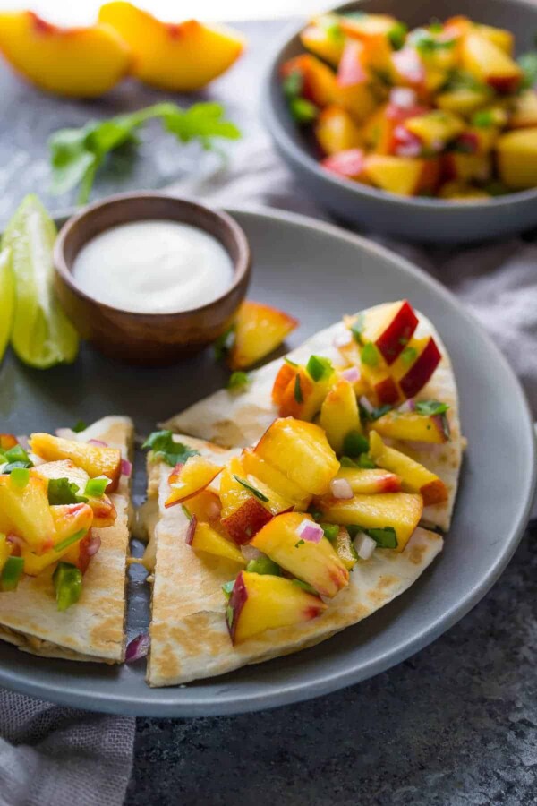 sweet chili chicken quesadillas with peach salsa on gray plate with lime wedge