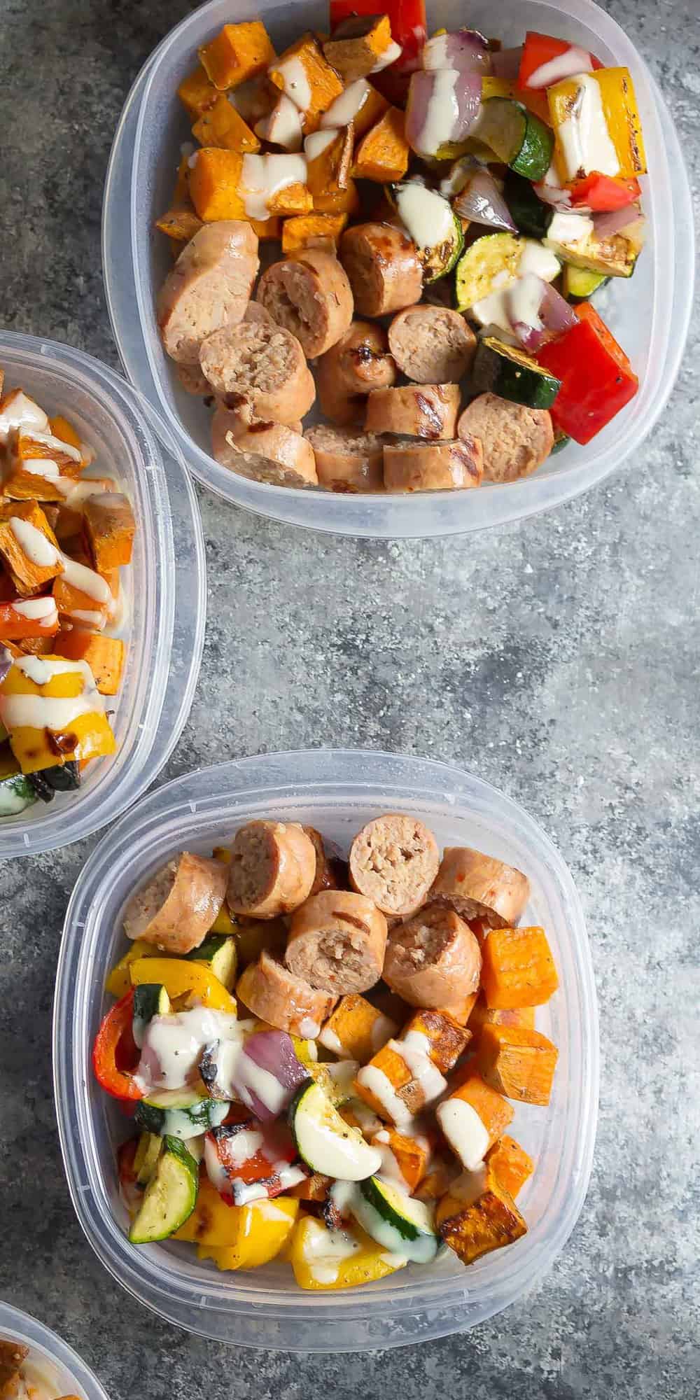 overhead view of Turkey Sausage & Sweet Potato Lunch Bowls portioned out in meal prep containers