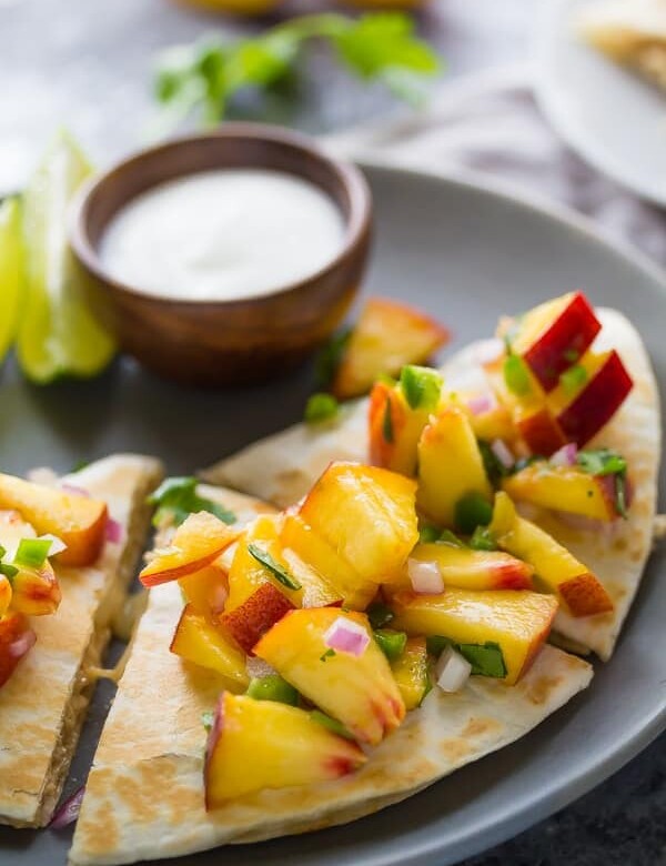sweet chili chicken quesadillas with peach salsa on gray plate with lime wedge