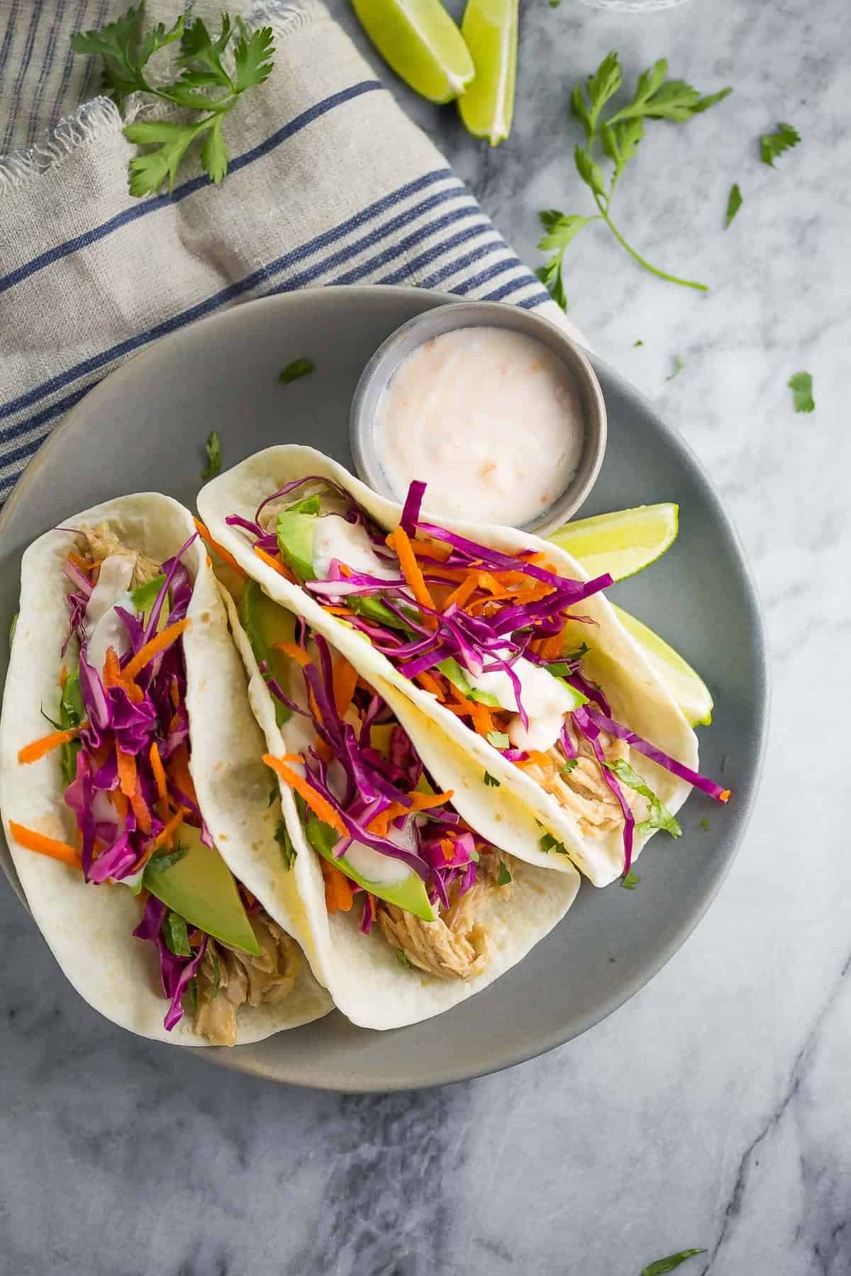 Sweet Chili Chicken Tacos plated with slaw and yogurt sauce