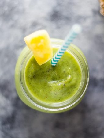 pineapple and turmeric smoothie in mason jar with blue straw