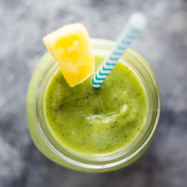 pineapple and turmeric smoothie in mason jar with blue straw