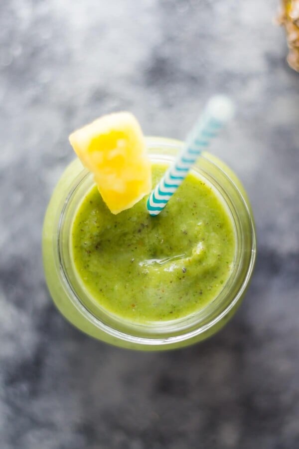 pineapple and turmeric smoothie in mason jar with blue straw