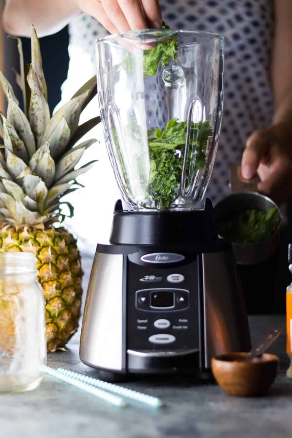 placing ingredients for breakfast smoothies into a blender