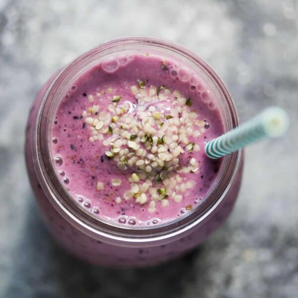 blueberry coconut water smoothie with blue straw in mason jar