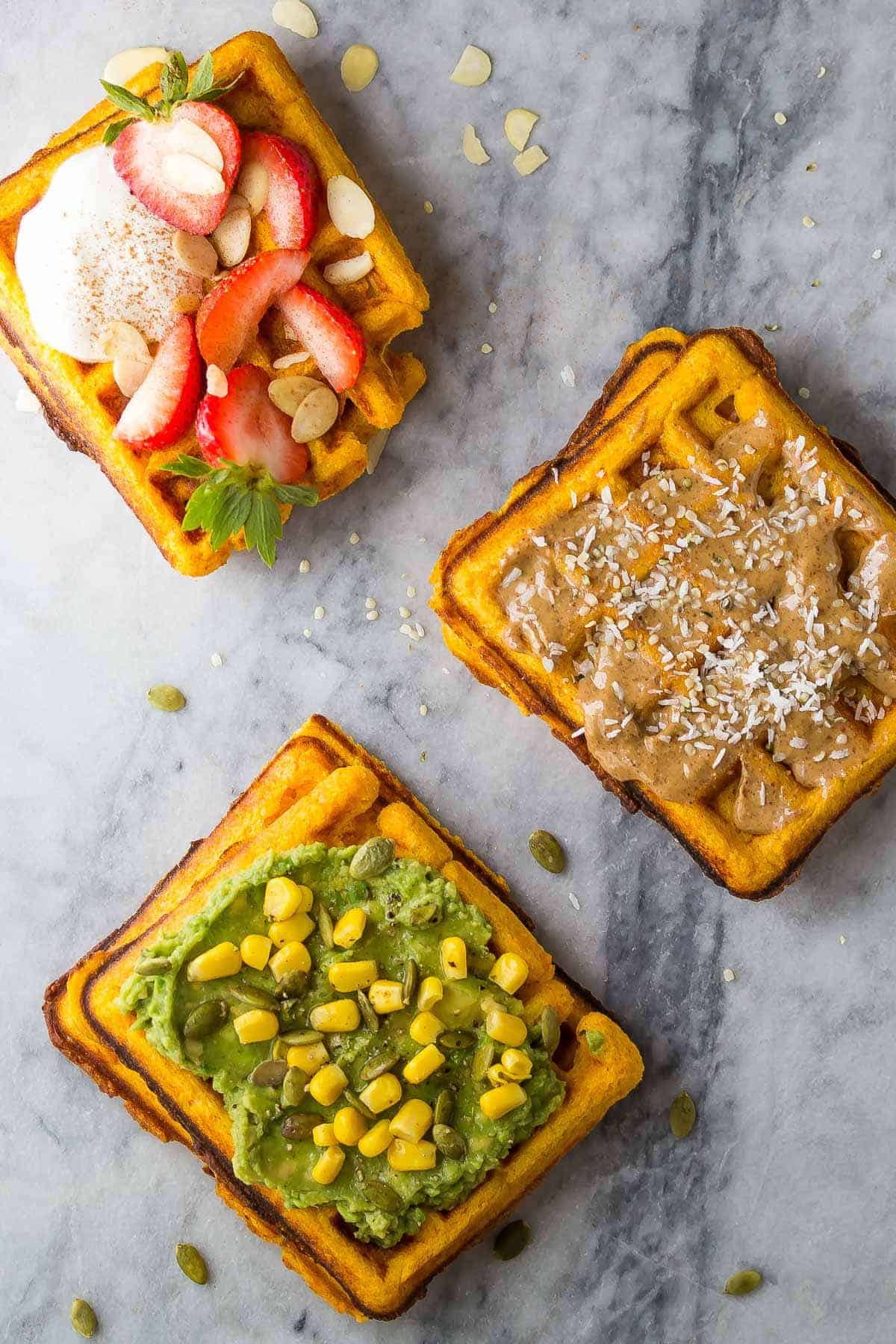 3 Freezer Sweet Potato Waffles with different toppings, strawberries and yogurt, almond butter and hemp seeds, and avocado and corn with pepitas