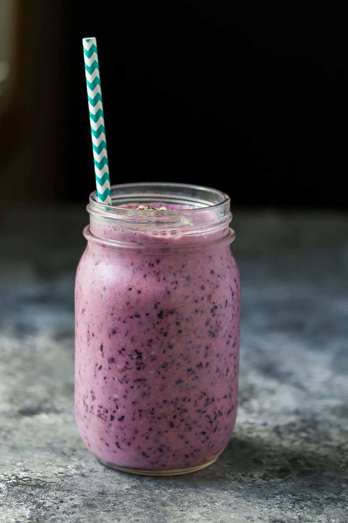 Blueberry Coconut Water Smoothie in a mason jar with a blue straw