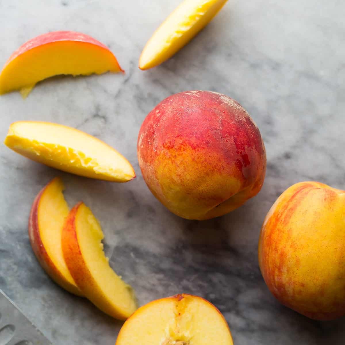 overhead shot of peaches whole and sliced