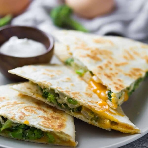 three triangle pieces of broccoli cheddar breakfast quesadilla on gray plate