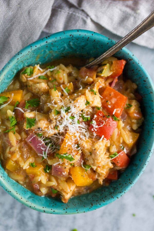 cajun chicken orzo in blue bowl with a spoon