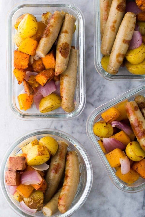 overhead shot of four glass meal prep containers with sausage breakfast bowls