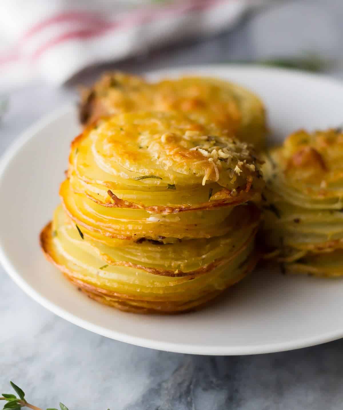 plate with three herb and garlic potato stacks