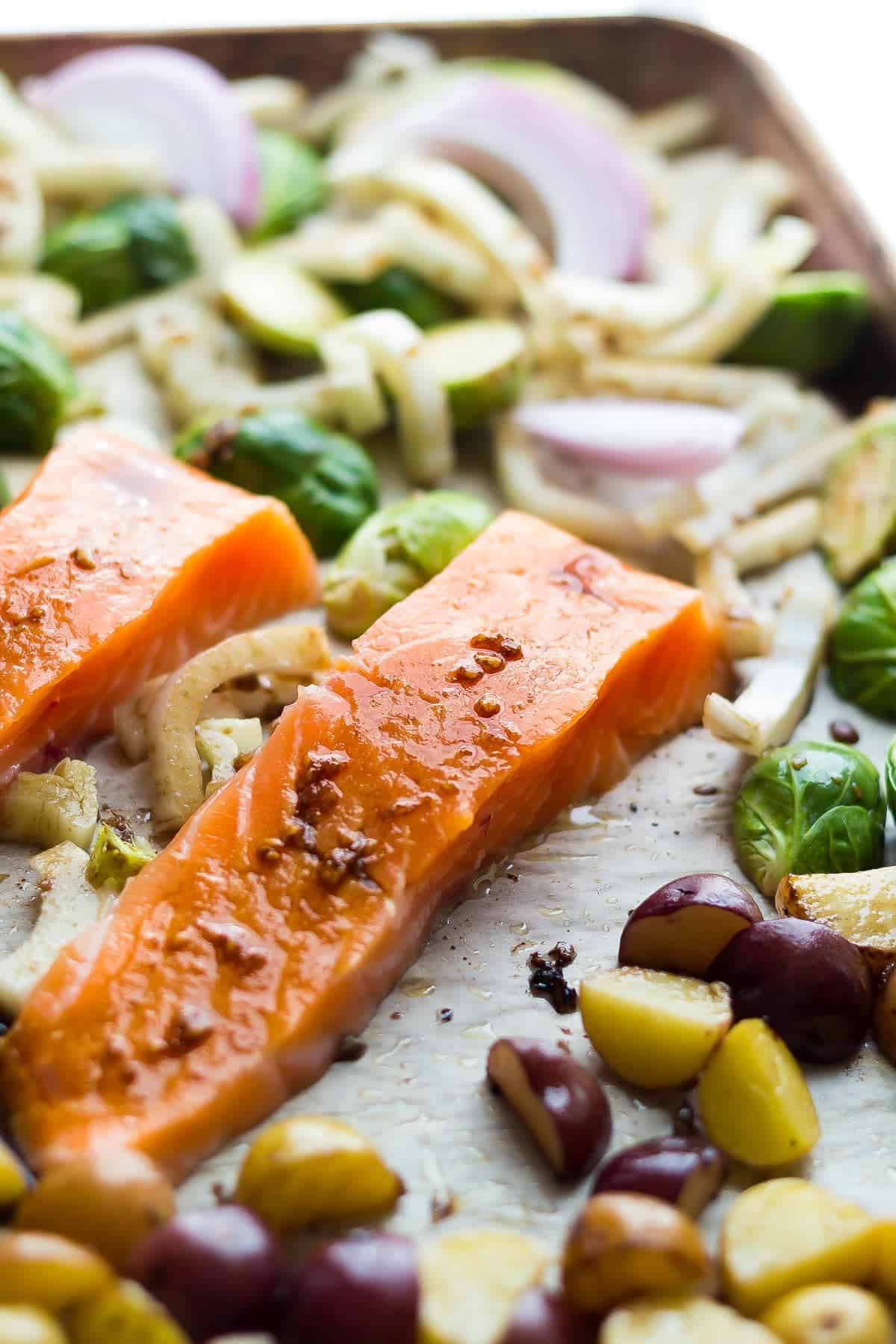 Mediterranean Salmon, potatoes, onion and brussels sprouts ready to cook on a baking sheet