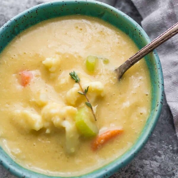 blue bowl filled with quinoa and cauliflower chowder with spoon