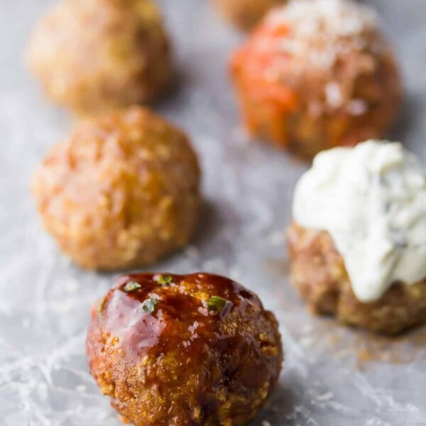 five baked turkey meatballs lined up on parchment paper