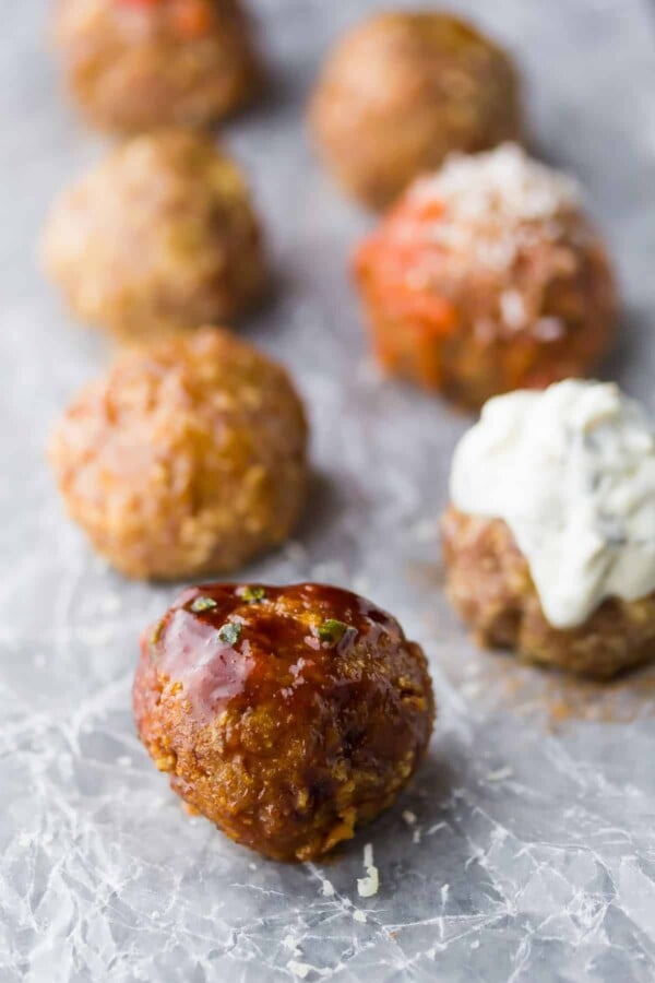 five baked turkey meatballs lined up on parchment paper