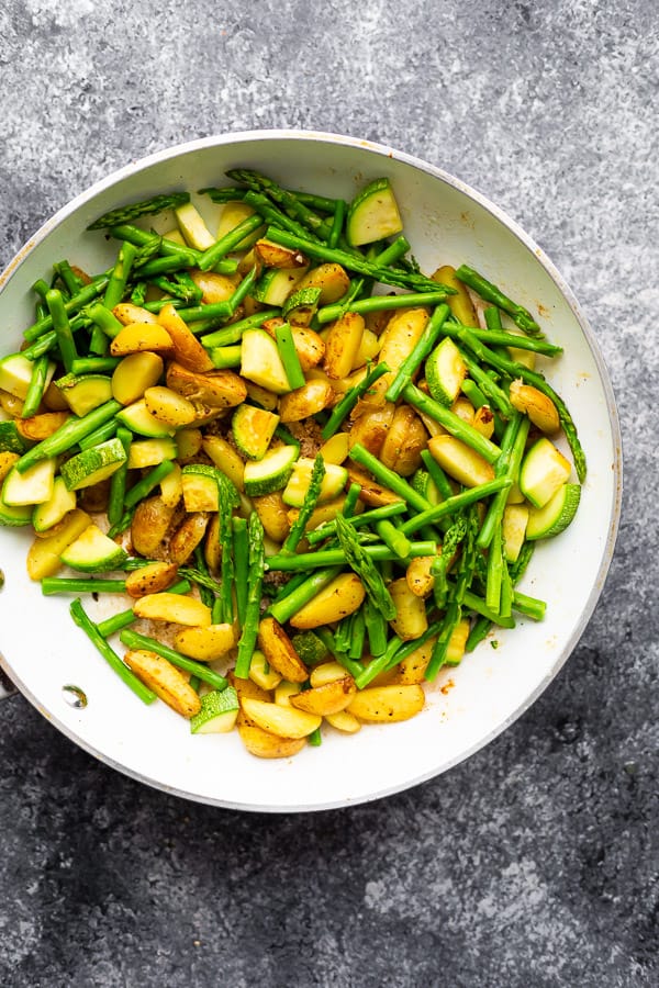 potatoes and vegetables for one pan chicken in frying pan