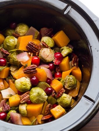 slow cooker filled with brussels sprouts cranberries butternut squash and pecans
