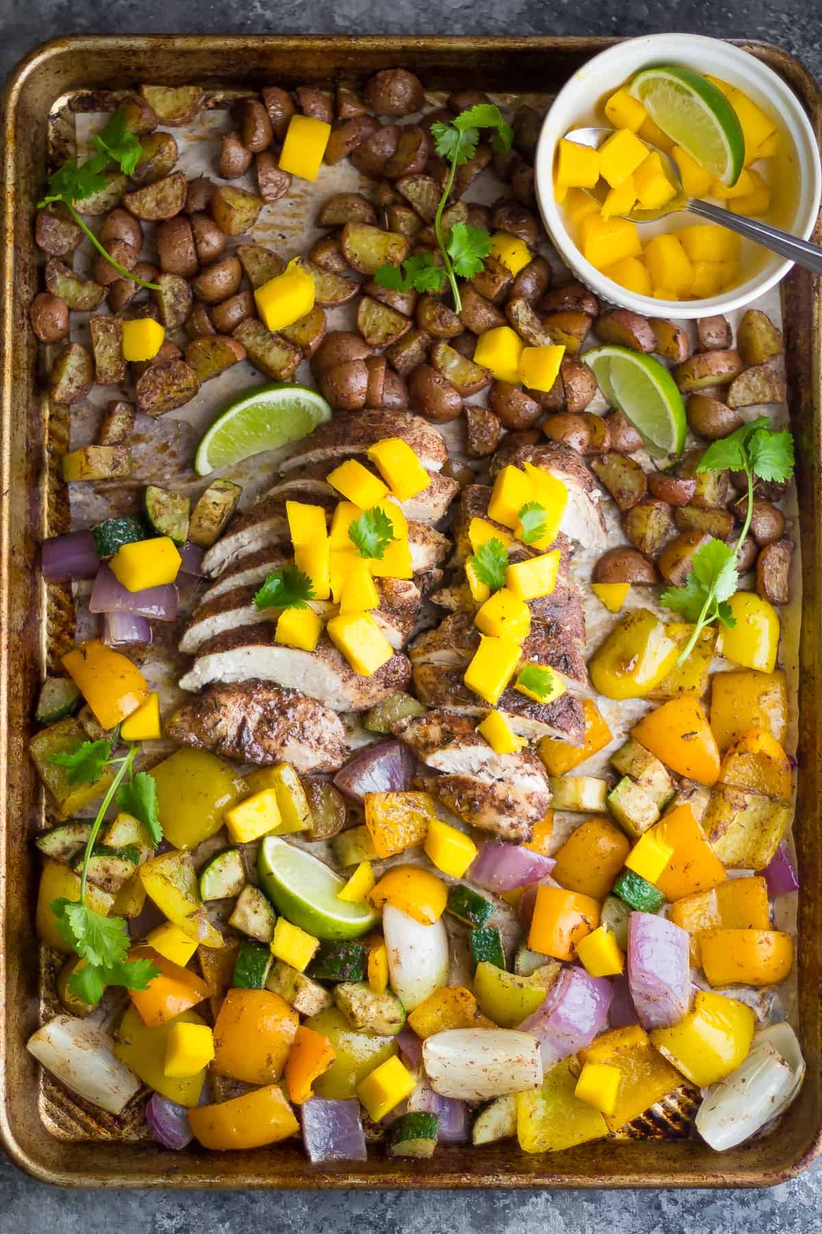 This Jamaican Chicken Sheet Pan Dinner is topped with fresh mango, cooks on one pan, and is ready in 30 minutes!