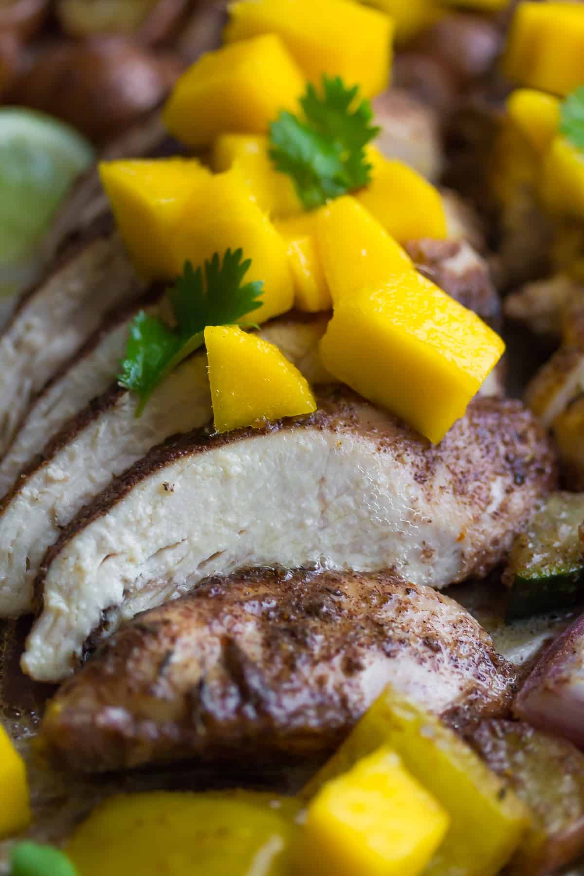 Jamaican Chicken Sheet Pan Dinner topped with fresh mango