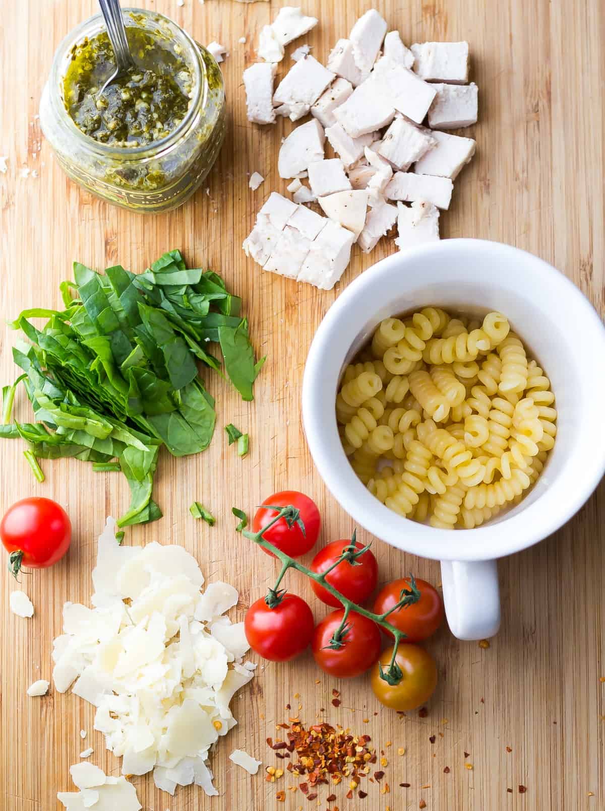 pesto chicken mug pasta ingredients on cutting board
