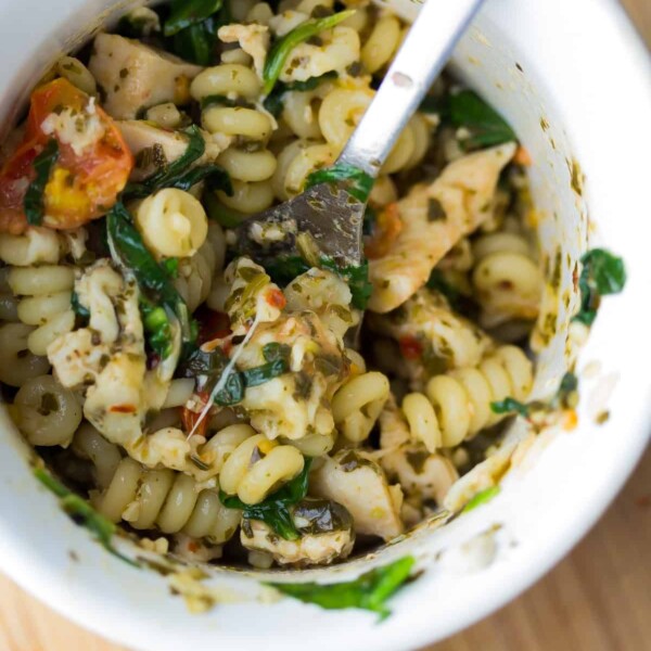 overhead shot of pesto chicken mug pasta with a fork