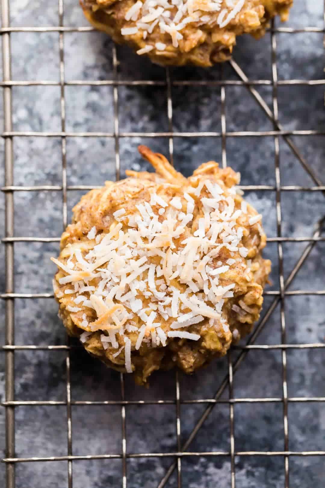 overhead view of Apple Almond Butter Snack Cookie with shredded coconut cooling on wire rack