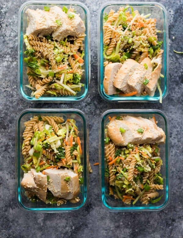 four glass containers with sesame chicken pasta salad lunch bowls