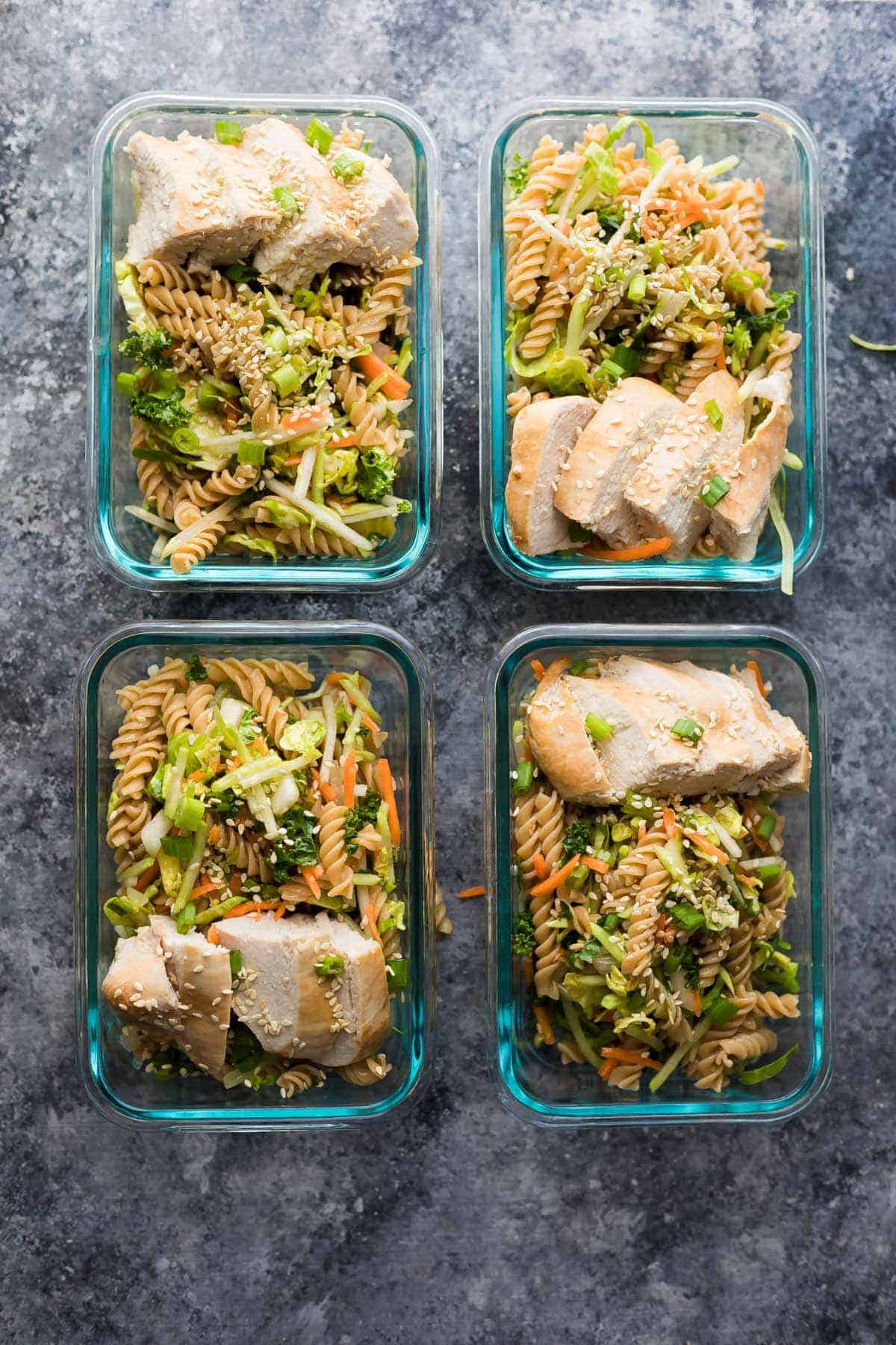 overhead view of four glass containers with Sesame Chicken Pasta Salad