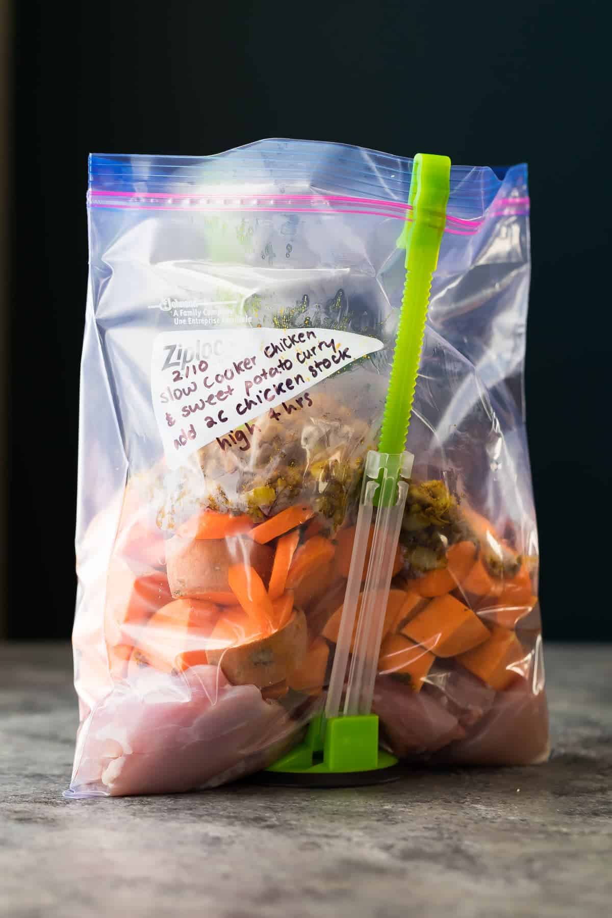 Freezer bag standing upright filled with raw ingredients for the Slow Cooker Sweet Potato Chicken Curry 