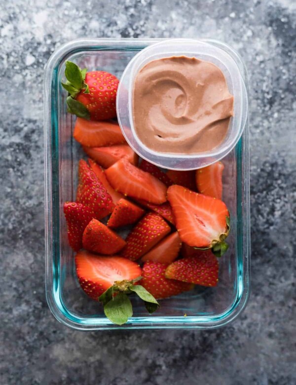 overhead shot of cut strawberries with greek yogurt dip in container