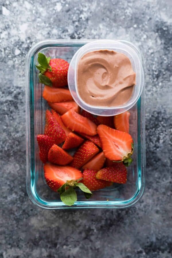 overhead shot of cut strawberries with greek yogurt dip in container