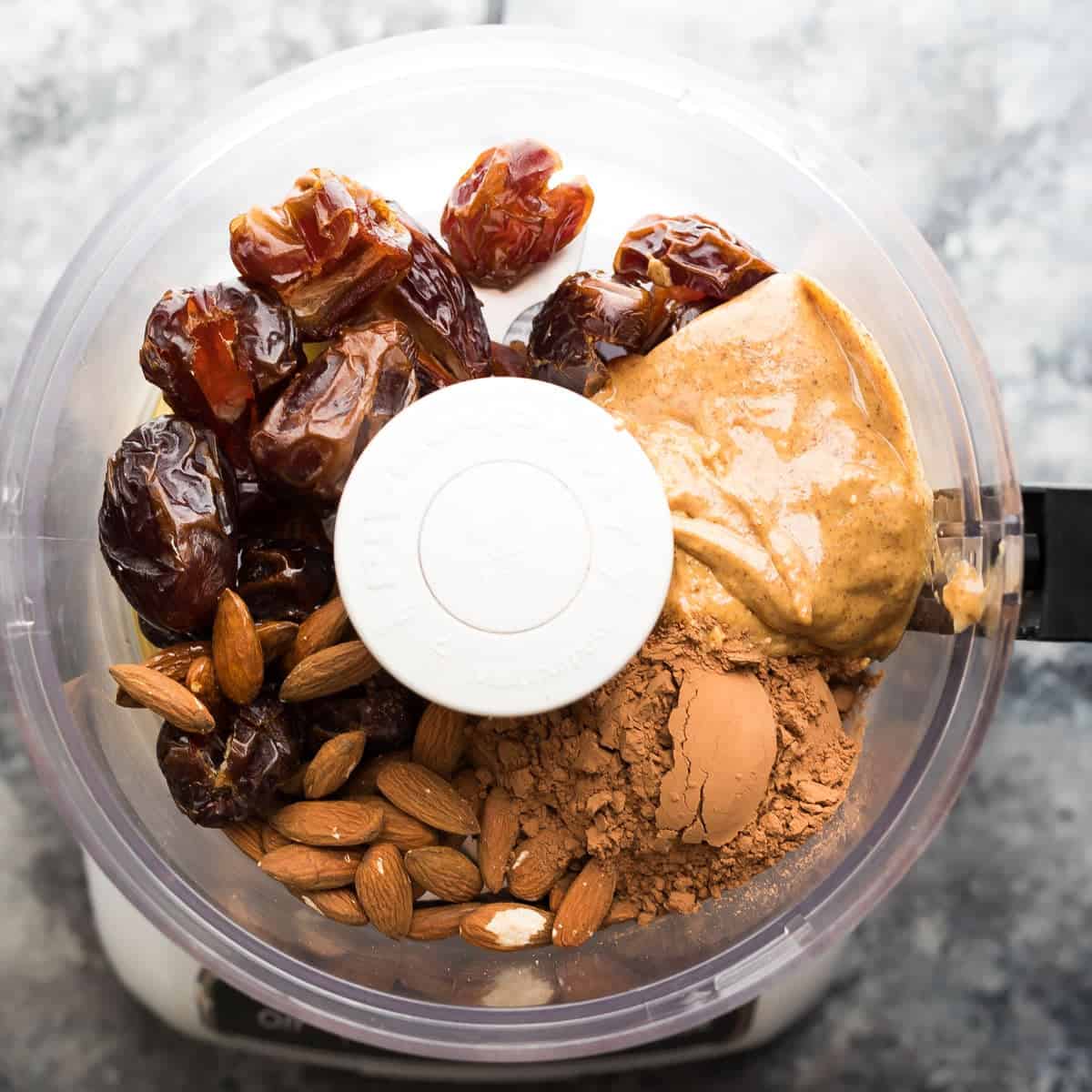 overhead view of raw ingredients for Chocolate Almond Quinoa bars in the food processor