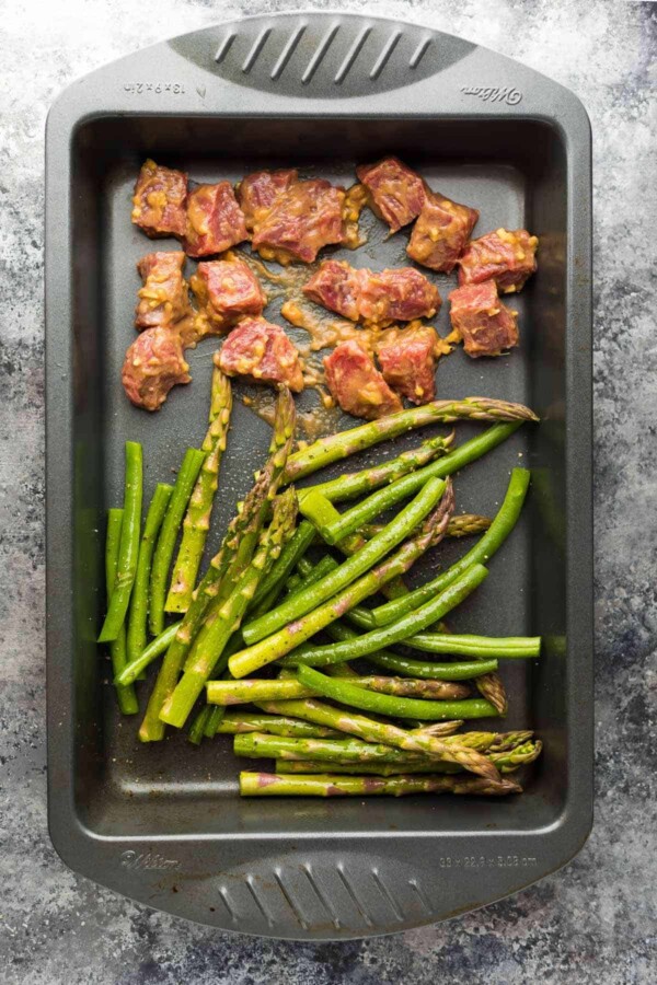 Hoisin Ginger steak cubes and cut asparagus and green beans in baking pan