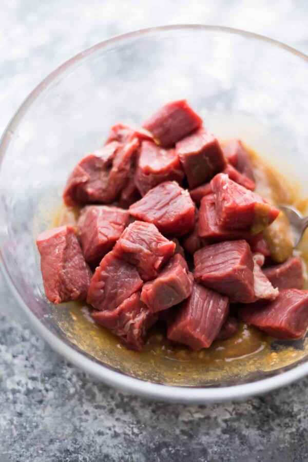 raw cubes of steak in hoisin ginger marinade in glass bowl