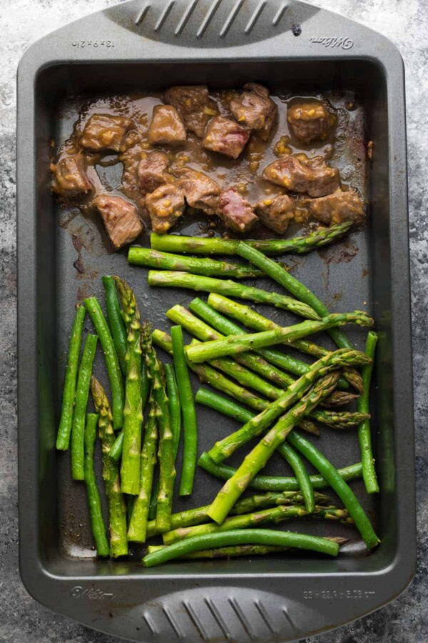 overhead shot of hoisin ginger steak asparagus and green beans on sheet pan