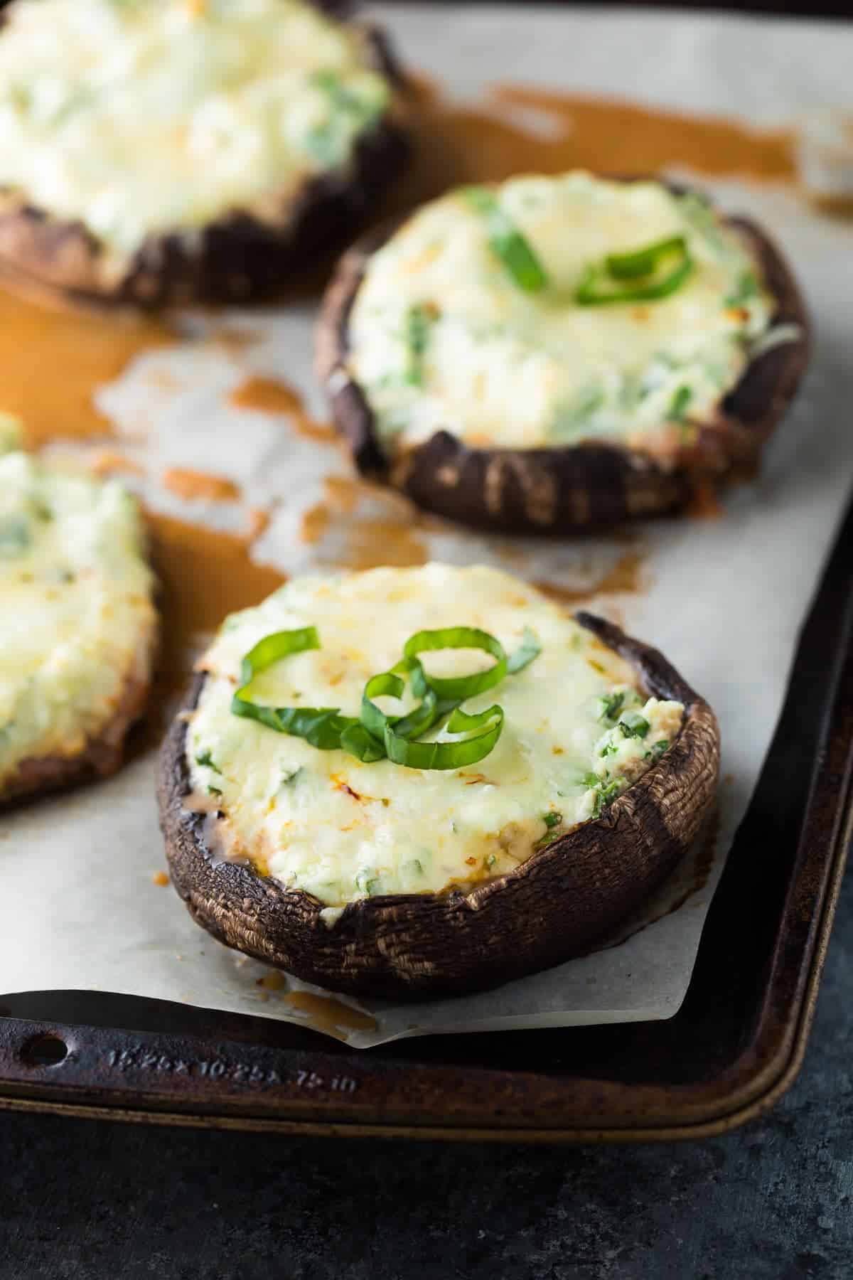 close up view of Lasagna stuffed portobello mushrooms on baking sheet after baking