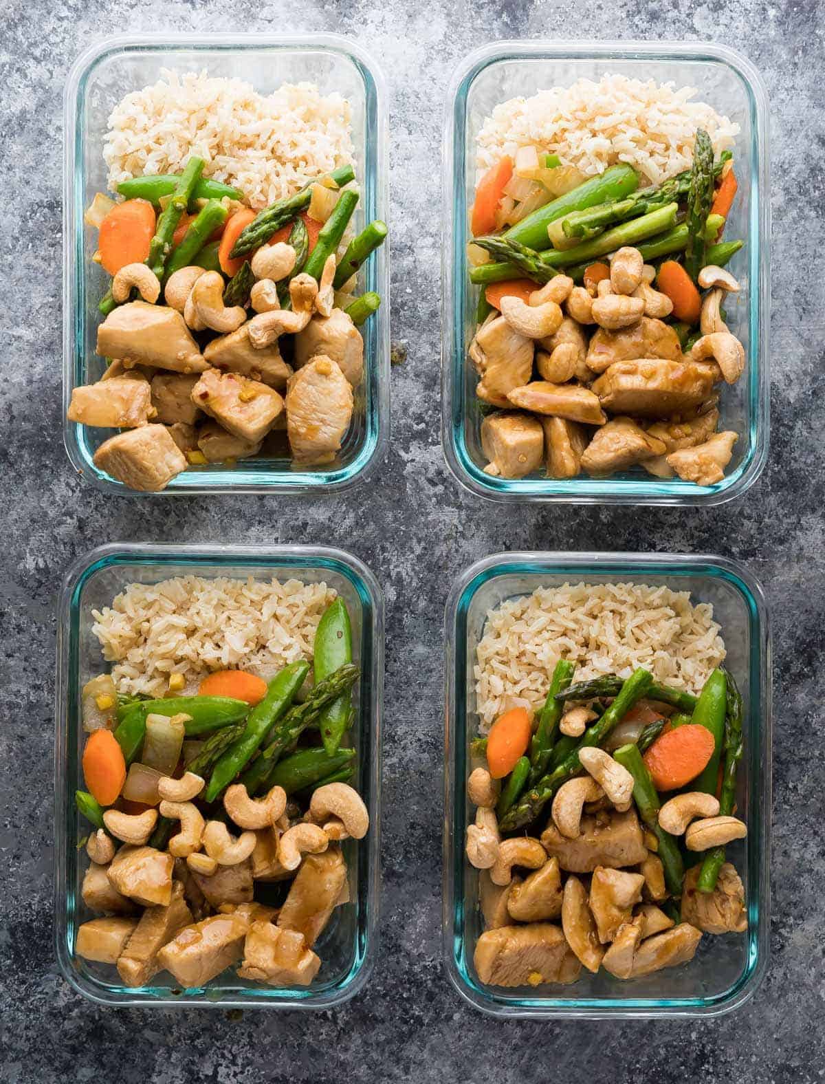 Overhead view of four maple ginger chicken meal prep lunch bowls in glass containers